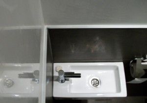 Decoratieve afwerking in het toilet. Combinatie van stucwerk met tegels.